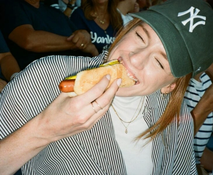 Chica comiendo perrito caliente