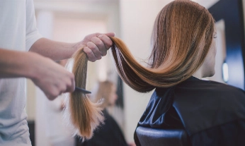 Una chica cortándose el pelo en un salón de peluquería sostenible